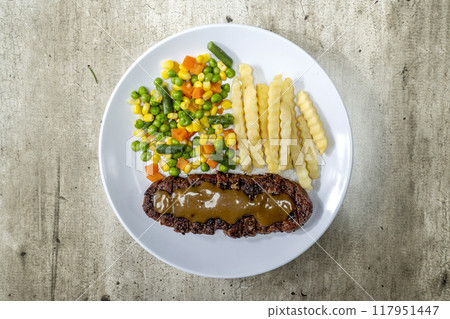 A plate of food with a piece of sirloin meat 117951447