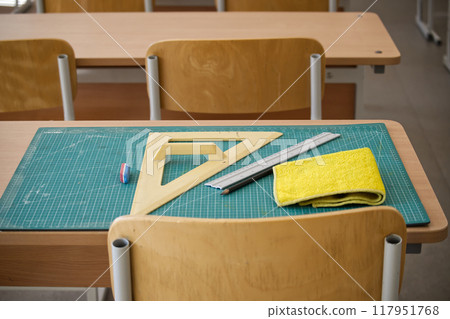 Classroom desk with math tools, ruler, and eraser on a cutting mat Classroom desk with math tools, ruler, and eraser on a cutting mat 117951768