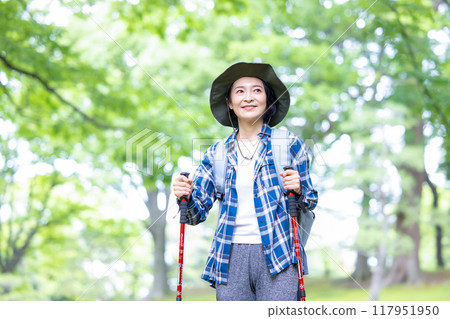 Middle-aged woman enjoying hiking Middle-aged woman enjoying hiking 117951950