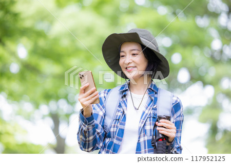 徒步旅行的女人看著智慧型手機 117952125