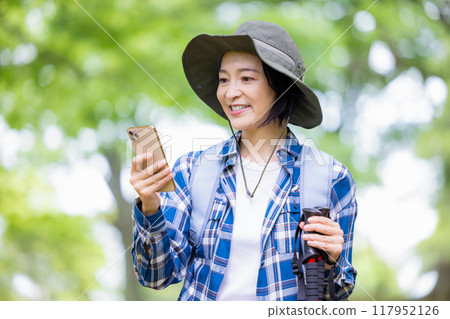 Hiking woman looking at smartphone 117952126