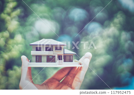 持有房屋模型的人的手和綠色模糊背景 117952475