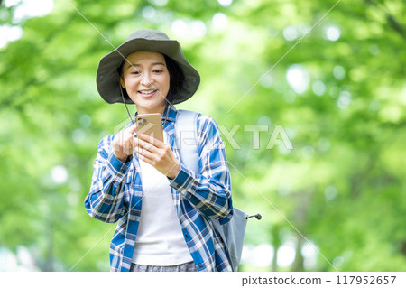 Hiking woman looking at smartphone 117952657