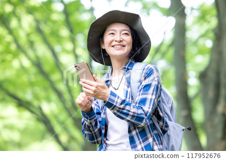 徒步旅行的女人看著智慧型手機 117952676