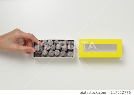 Chocolate balls in a gift box on a light background 117952776