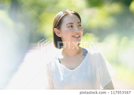 Smiling young woman walking in sportswear 117953567