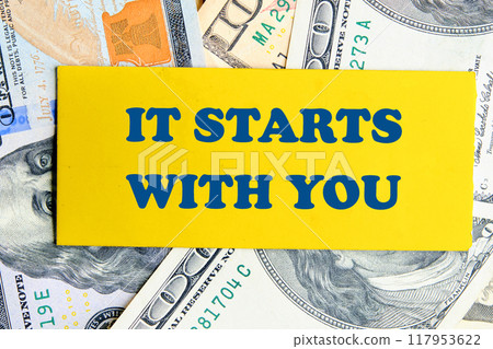 Conceptual it starts with you symbol. Copy space. It starts with you words written a conceptual phrase on a yellow business card against the background of American dollars 117953622