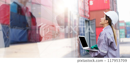 Portrait of smart and good looking Asian container yard or custom officer standing in the container yard and looking at the sky, photograph with double exposure showing businesspeople shaking hands. 117953709