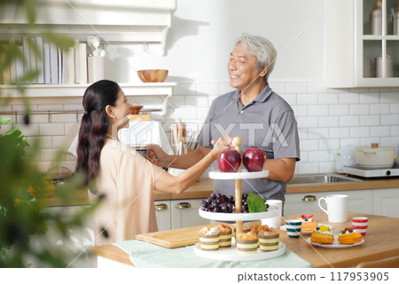 Asia happy older senior elderly couple dance waltz after cooking at kitchen room. Asia happy older senior elderly couple dance waltz after cooking at kitchen room. 117953905