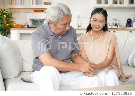 Asia senior elderly man comforting and hold hands him wife after having problems relationship.   117953926