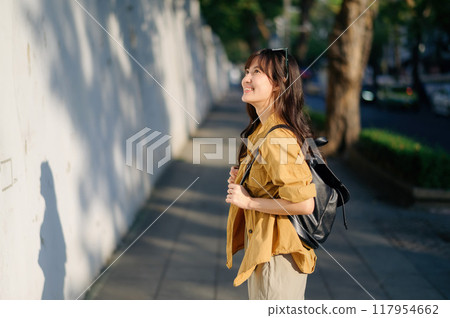 Traveler young asian woman in her 30s embarks on a solo trip to Bangkok. This photo captures the essence of finding balance and exploring new destinations. 117954662