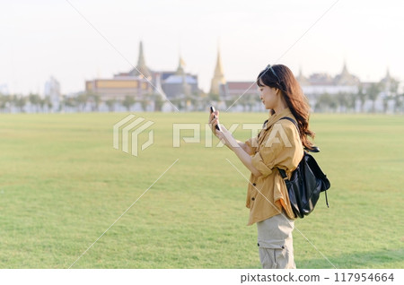 Traveler asian woman in her 30s explores the Grand Palace complex. This photo embodies the fascination with Thai culture and heritage. 117954664