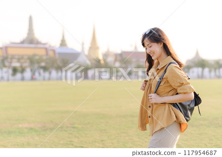 A Traveler Asian woman in her 30s exploring Wat Pra Kaew. From stunning architecture to friendly locals, she cherishes every moment, capturing it all in her heart and camera for years to come. 117954687