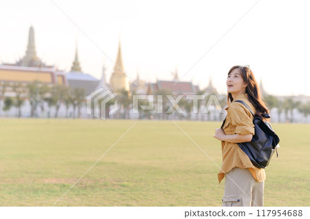 A Traveler Asian woman in her 30s exploring Wat Pra Kaew. From stunning architecture to friendly locals, she cherishes every moment, capturing it all in her heart and camera for years to come. 117954688