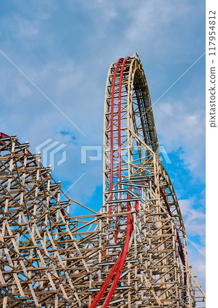 Roller coaster attraction in amusement park. Entertainment at summer holiday 117954812