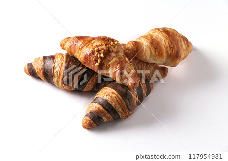 Freshly baked golden croissants in various flavors arranged on a white background. 117954981