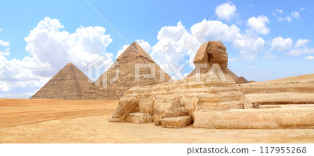 Famous Great Sphinx and pyramids of Chephren and Cheops, Cairo, Egypt. Great Pyramids and ancient statue of Sphinx, mythical creature with head of man and body of lion, Giza complex (Giza Necropolis) 117955268