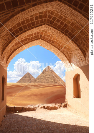 Ancient arch at entrance to Great Pyramids in Giza pyramid complex (Giza Necropolis), Egypt. View of sand dunes and pyramids of Chephren and Cheops through stone arch. Travel, resort, vacation concept 117955281