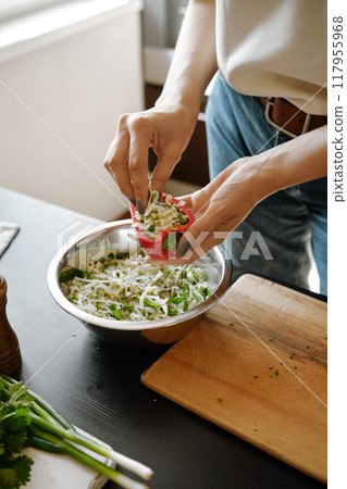 Female hands making stuffed bell peppers 117955968
