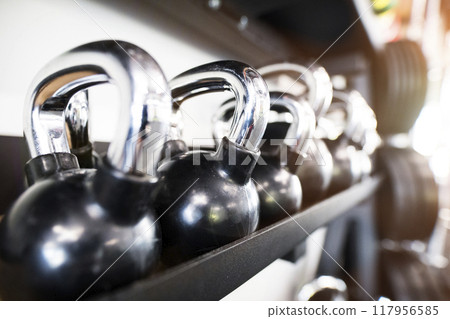 Kettlebells in racks. Gym equipment for strength training. 117956585