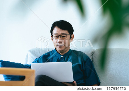 一個男人在客廳操作電腦 117956750