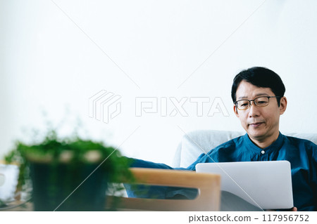 一個男人在客廳操作電腦 117956752