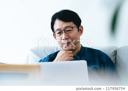 一個男人在客廳操作電腦 117956754