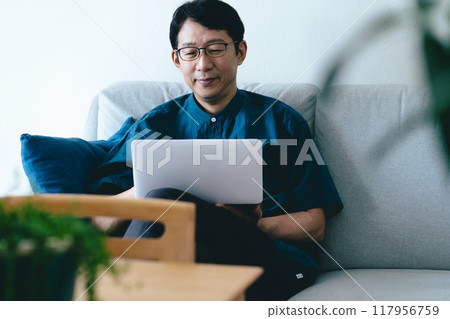 一個男人在客廳操作電腦 117956759