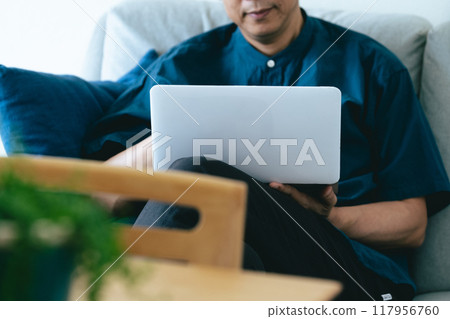一個男人在客廳操作電腦 117956760