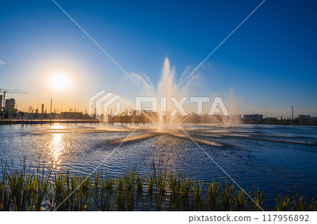 Large fountains illuminated by sunlight in the city park Large fountains illuminated by sunlight in the city park 117956892