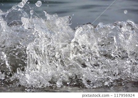White foam and sea water drop splashes slow motion with sand and blue water White foam and sea water drop splashes slow motion with sand and blue water 117956924
