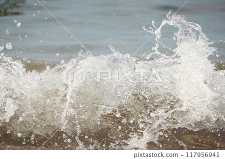 White foam and sea water drop splashes slow motion with sand and blue water White foam and sea water drop splashes slow motion with sand and blue water 117956941