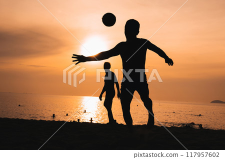 Silhouette of a man kicking a ball playing traditional Asian beach football on beach by the sea at sunset Silhouette of a man kicking a ball playing traditional Asian beach football on beach by the sea at sunset 117957602