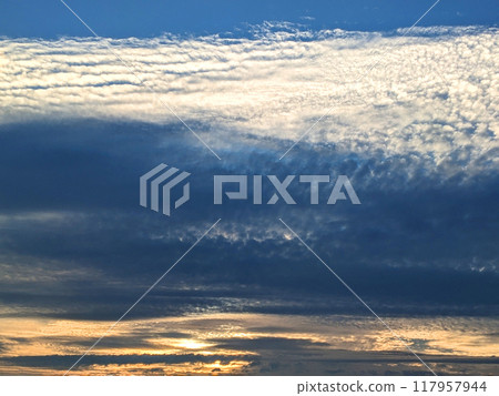 Dark Moody Thunder Clouds Sunset Clouds in a Blue Sky as A Skyscape Background Dark Moody Thunder Clouds Sunset Clouds in a Blue Sky as A Skyscape Background 117957944