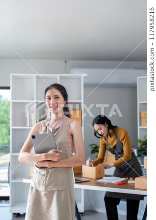 Female entrepreneurs collaborating on online sales packaging Female entrepreneurs collaborating on online sales packaging 117958216