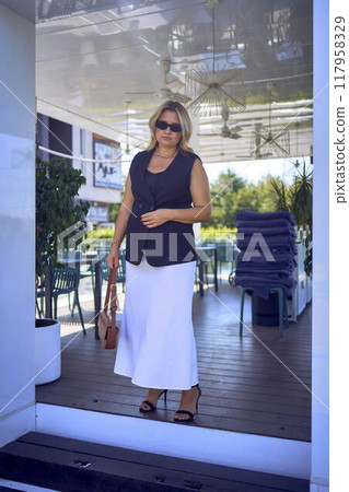 a   middle-aged plus size woman in old money style clothes in a fancy restaurant 117958329