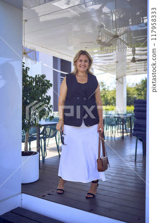 a   middle-aged plus size woman in old money style clothes in a fancy restaurant 117958333