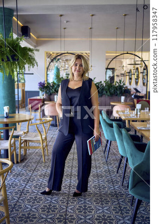 a middle-aged plus size woman in old money style clothes in a fancy restaurant a middle-aged plus size woman in old money style clothes in a fancy restaurant 117958347