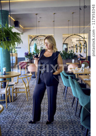 a   middle-aged plus size woman in old money style clothes in a fancy restaurant 117958348