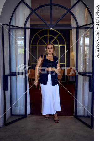 a  middle-aged plus size woman in old money style clothes in a fancy restaurant 117958616