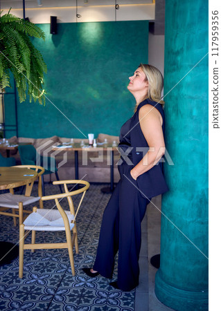 a middle-aged plus size woman in old money style clothes in a fancy restaurant a middle-aged plus size woman in old money style clothes in a fancy restaurant 117959356