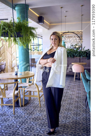 a portrait of middle-aged plus size woman in old money style clothes in a fancy restaurant a portrait of middle-aged plus size woman in old money style clothes in a fancy restaurant 117959390