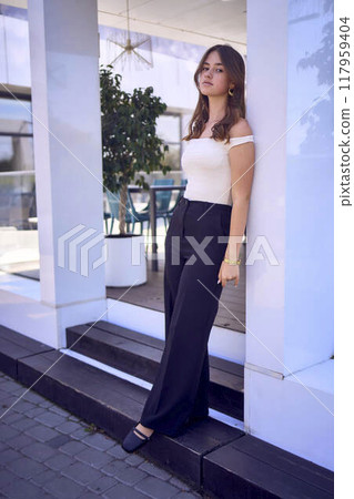 a    portrait of  16-year-old teenage girl in old money style clothes in  fancy restaurant 117959404