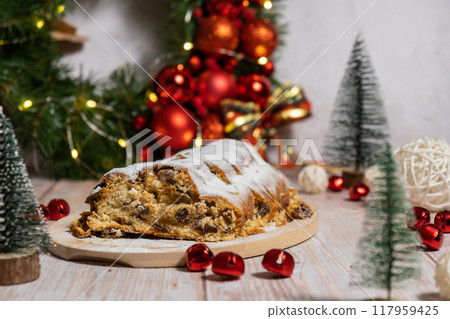 Homemade Christmas traditional cake pie with marzipan nuts and dried fruits pastry dessert stollen. Winter holidays season atmosphere. Delicious tasty composition home table setting 117959425