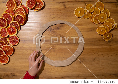 DIY process of woman making Christmas arrangement with dried oranges and grapefruits. Series of handmade craft instruction. Zero waste eco-friendly winter holiday decoration DIY process of woman making Christmas arrangement with dried oranges and grapefruits. Series of handmade craft instruction. Zero waste eco-friendly winter holiday decoration 117959440