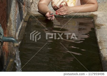 Woman makes a wish at the fountain 117959496