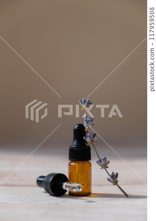 Lavender flowers with dropper glass bottle of essential oil. Concept of alternative medicine. Herbal natural detox treatment. Stress relief calming mental health products Lavender flowers with dropper glass bottle of essential oil. Concept of alternative medicine. Herbal natural detox treatment. Stress relief calming mental health products 117959508