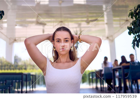 a    portrait of  16-year-old teenage girl in old money style clothes in  fancy restaurant 117959539