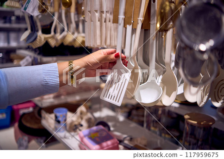 a middle-aged plus-size woman choose clothes and decor in a store 117959675