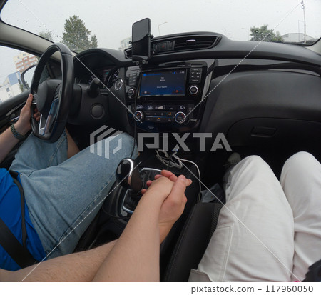 Couple Holding Hands in a Car on a Rainy Day 117960050